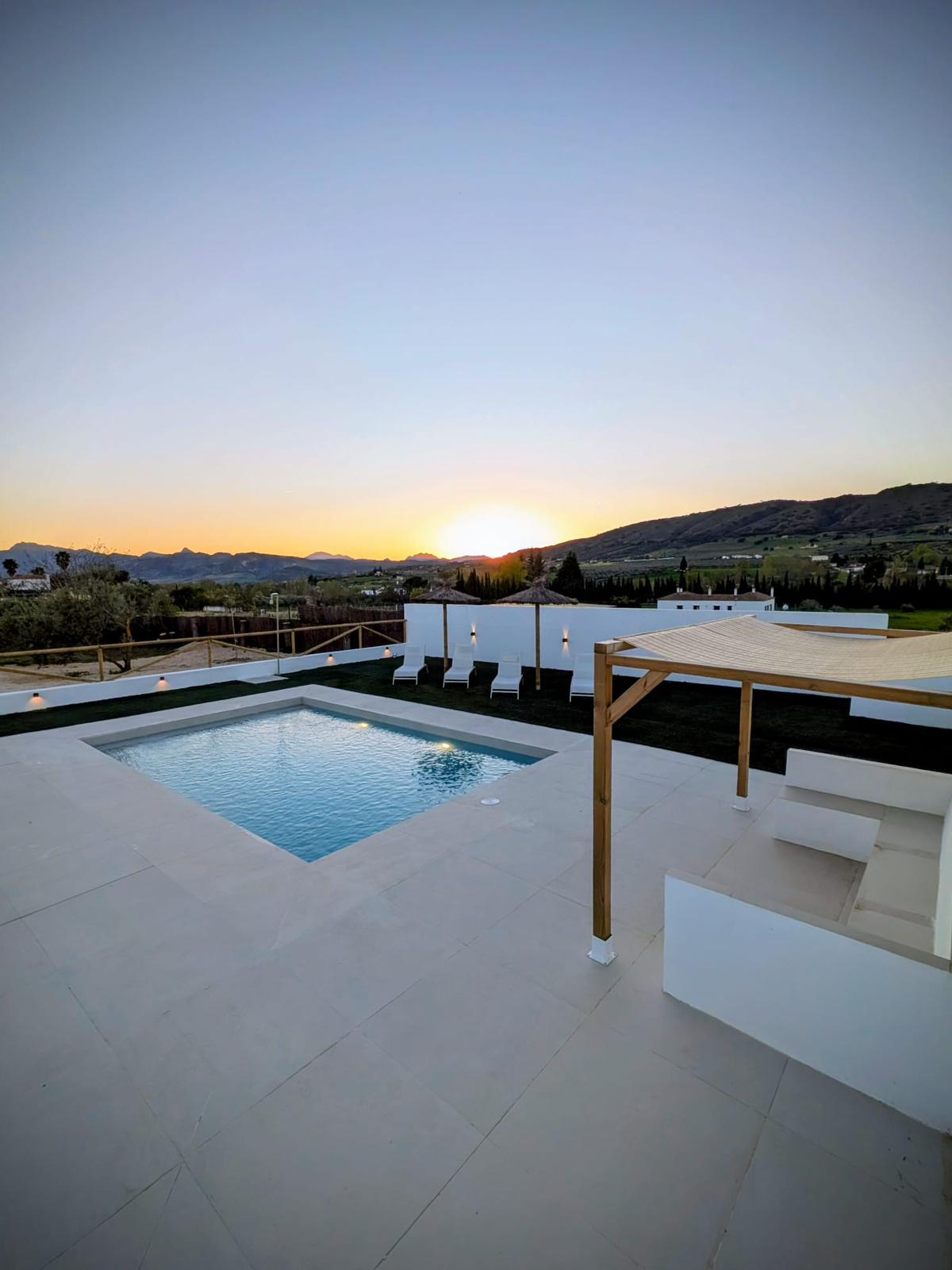 Piscina privada al atardecer con vistas a la Serranía